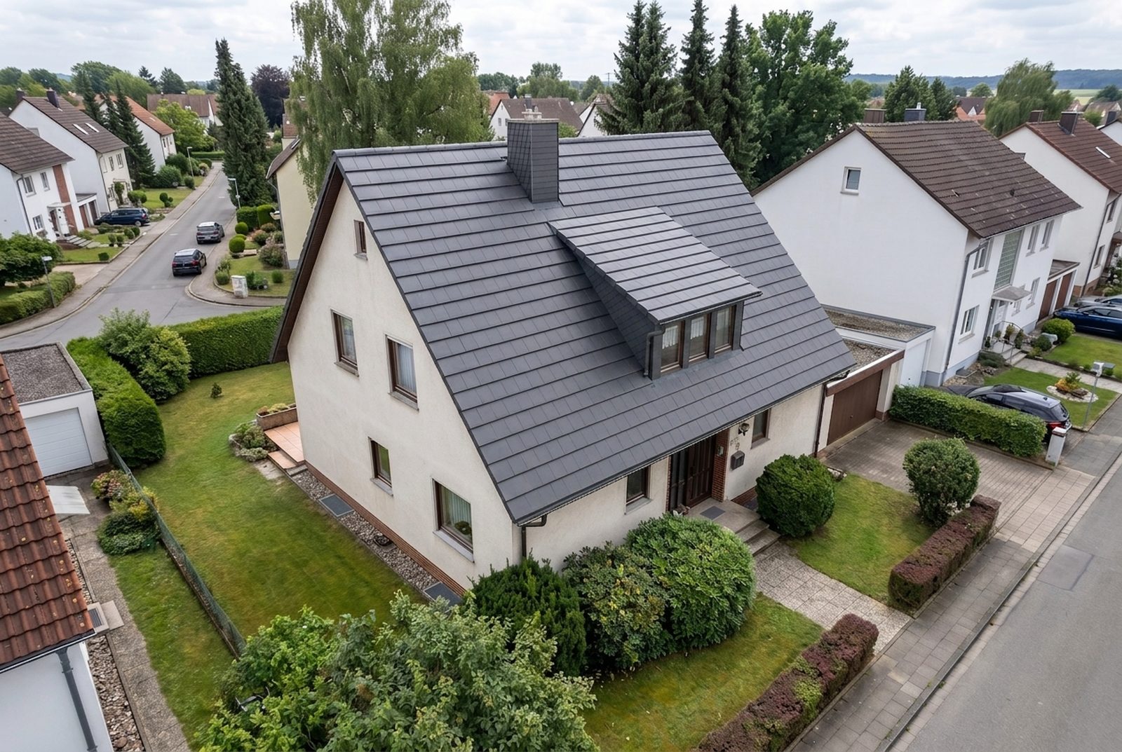 Drohnenfoto eines Einfamilienhauses mit neuen anthrazitfarbenen, edelengobierten Flachziegeln